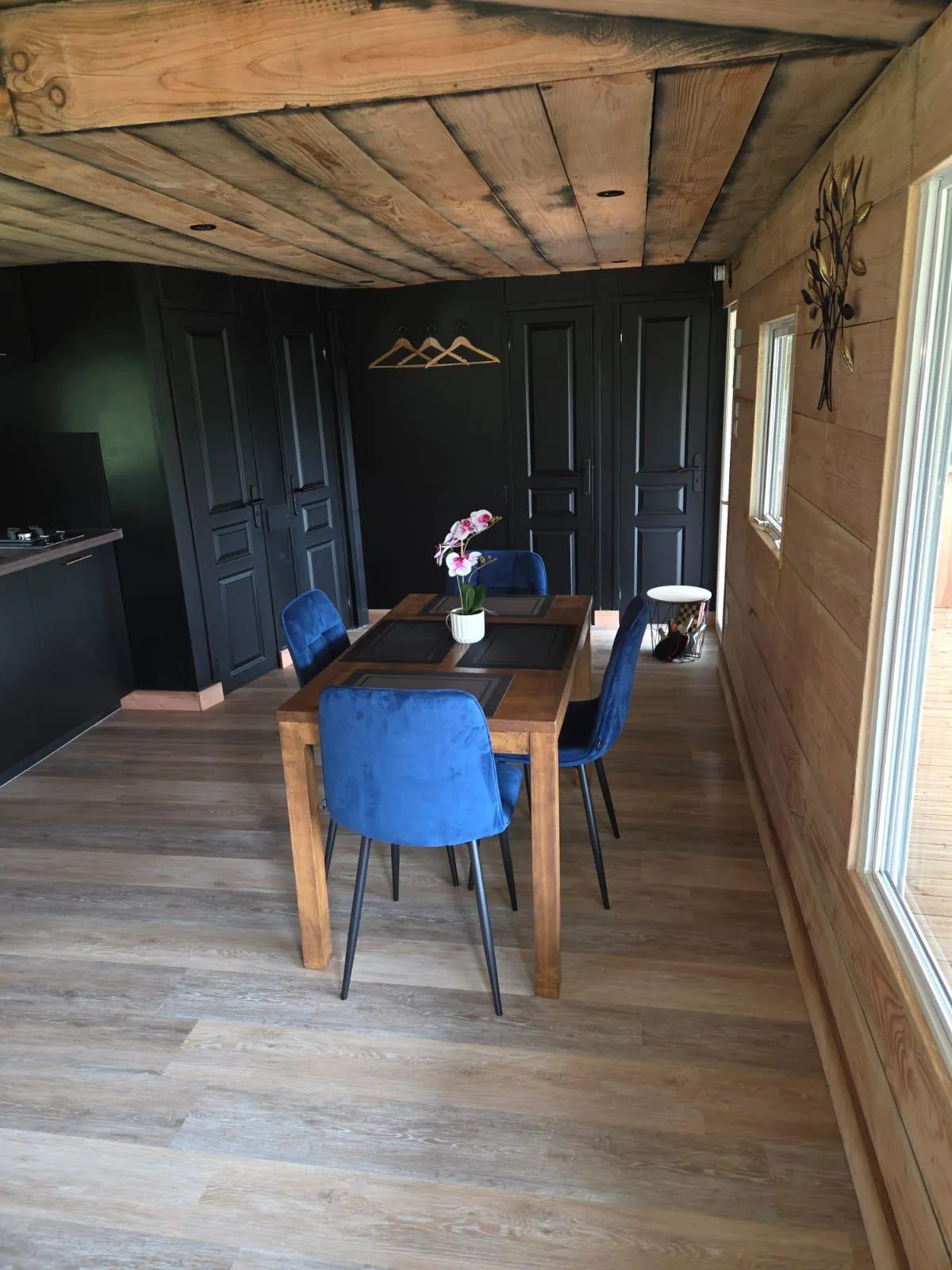 Le coin repas en bois avec une table dressée pour quatre personnes